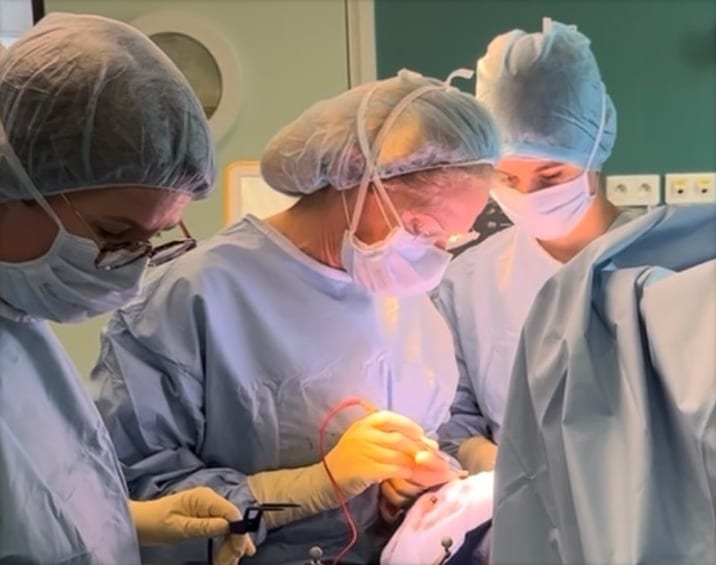 Trois chirurgiens concentrés sur le champ opératoire
